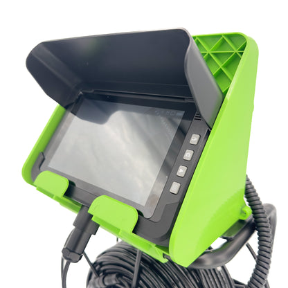 Green and black industrial inspection camera with screen on a white background